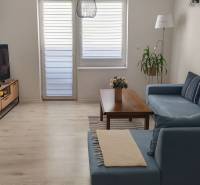 Living room with wood-patterned flooring, blue sofa, and coffee table.