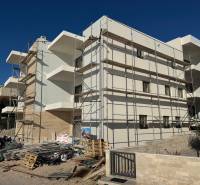 A building in the town of Mandre with scaffolding and construction materials, probably a 2-room apartment.