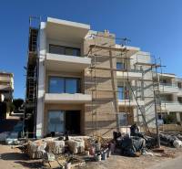 A new building in Mandre with 2-bedroom apartments, unfinished facade, scaffolding, and construction materials.