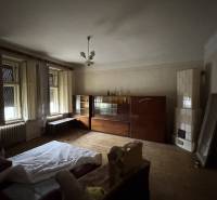 Living room in a family house with a wooden decor floor and a tiled stove.