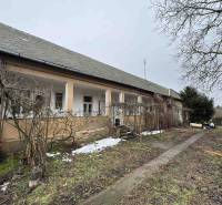 A family house on SNP in Šahy, in front of which there is a garden with bare branches and snow.