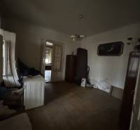 A room in a family house with a wooden decor floor and older furnishings.