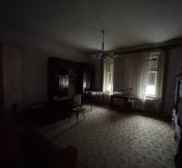 Dark living room, older furniture, carpet, curtains, and windows, family house.