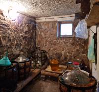 Stone walls of the cellar with demijohns in a family house.