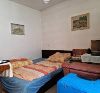 Interior of a family house with a bed, chair, table, and computer.