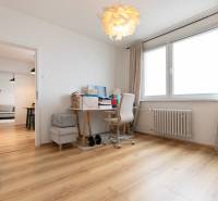 Home office with a desk and wood-patterned flooring in a 3-room apartment.