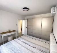 Bedroom with a double bed and a wardrobe, 3-room apartment, floor with wooden decor.