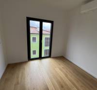 Recreational apartment with wood-patterned flooring and a large window on the upper floor.
