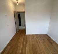 Recreational apartment with wood-patterned flooring and white walls.