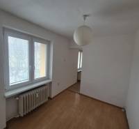 A room in a 2-room apartment with a wooden decor floor and a paper lamp.