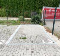 Parking space on a concrete surface in Bratislava - Ružinov with a parcel locker next to it.