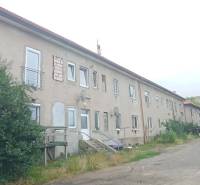 Apartment building on Partizánska Street in Lučenec with a simple facade and parking spaces.