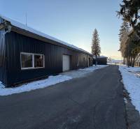 The road by the warehouses and halls on Pšurnovická Street in Bytča covered with snow.