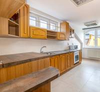 A kitchen unit in a family house with windows, space for both a microwave and an oven.