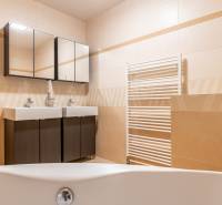 A bathroom in a family house, with a double sink and dark cabinets.
