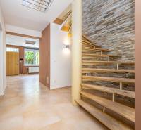 A staircase in a family house with a decorative wall and a floor with a wooden decor.