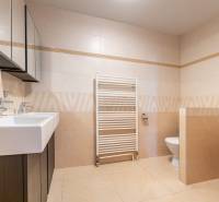 A bathroom in a family house with two sinks, a bidet, and a ladder radiator.