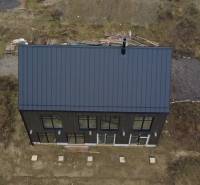 A family house in Liptovské Beharovce, Liptovský Mikuláš with a black roof and spacious windows.
