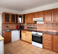 A kitchen with brown tiles and a countertop in a 4-room apartment.