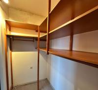 A wardrobe in a 4-room apartment with wooden shelves and a floor with a wooden decor.