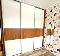 In the 4-room apartment, there is a built-in wardrobe with sliding doors and a floor with a wooden decor.