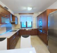 A kitchen in a family house with wooden cabinets and appliances, a floor with a wooden decor.