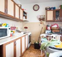 A kitchen in a 2-room apartment with a wood decor and kitchen cabinets.