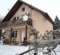 A family house in Trnava with a floor, a snow-covered garden, a terrace roof.