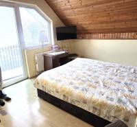 Bedroom in a family house with an exercise bike and a wooden decor floor.