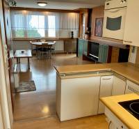 Kitchen and dining room in a 3-room apartment with wood-patterned flooring.