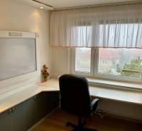 A study in a 3-room apartment with a window, a corner desk, and a floor with a wooden decor.