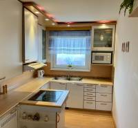 Kitchen in a 3-room apartment with white cabinets and a wood-patterned floor.