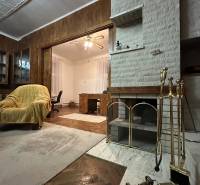 Living room in a 3-room apartment with a fireplace, decorative ceiling, and wood-patterned flooring.