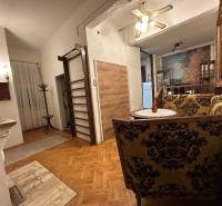 A living room of a three-room apartment with a wooden decor floor and decorative furniture.