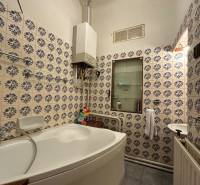 Bathroom in a 3-room apartment with a corner bathtub, gas boiler, and patterned tiles.