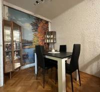 Dining room in a 3-room apartment with a wall mural and wood-patterned flooring.
