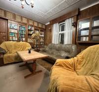 Living room in a 3-room apartment with wooden paneling, sofas, and a bookshelf.