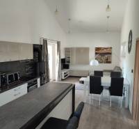 Kitchen area with a dining table and wooden decor flooring in a family house.