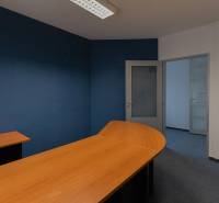 Blue and white office space with a wooden desk and glass doors in a 4-room apartment.