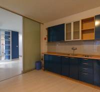 A kitchen in a 4-room apartment with blue cabinets and a wooden decor floor.