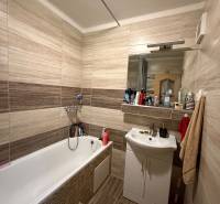 Bathroom in a 3-room apartment with a bathtub, sink, and tiles in neutral tones.