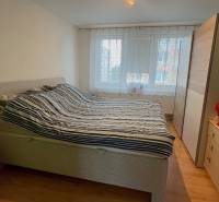 A bedroom with a large bed, a wardrobe, and a wooden decor floor in a 3-room apartment.
