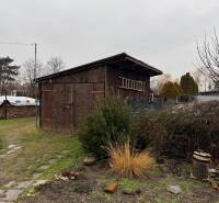 A wooden shelter with a garden in Ludanice, next to a path made of stone tiles.