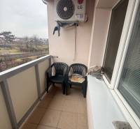 A balcony with plastic chairs and air conditioning in a 3-room apartment in Ludanice.