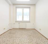 A small office with keys on the door, a window, and a light floor.