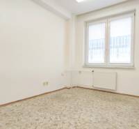 Office with a window, white walls, and tiled floor.