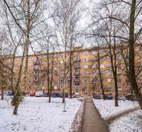 A panel apartment building surrounded by trees and snow in Fiľakovo, suitable for a 2-room apartment.