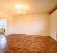 Interior of a 2-room apartment with a wooden decor floor and a chandelier.