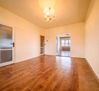 Living room in a two-room apartment with a wooden decor floor and a chandelier.