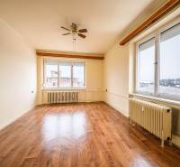 A spacious room with a wooden decor floor and large windows in a 2-room apartment.